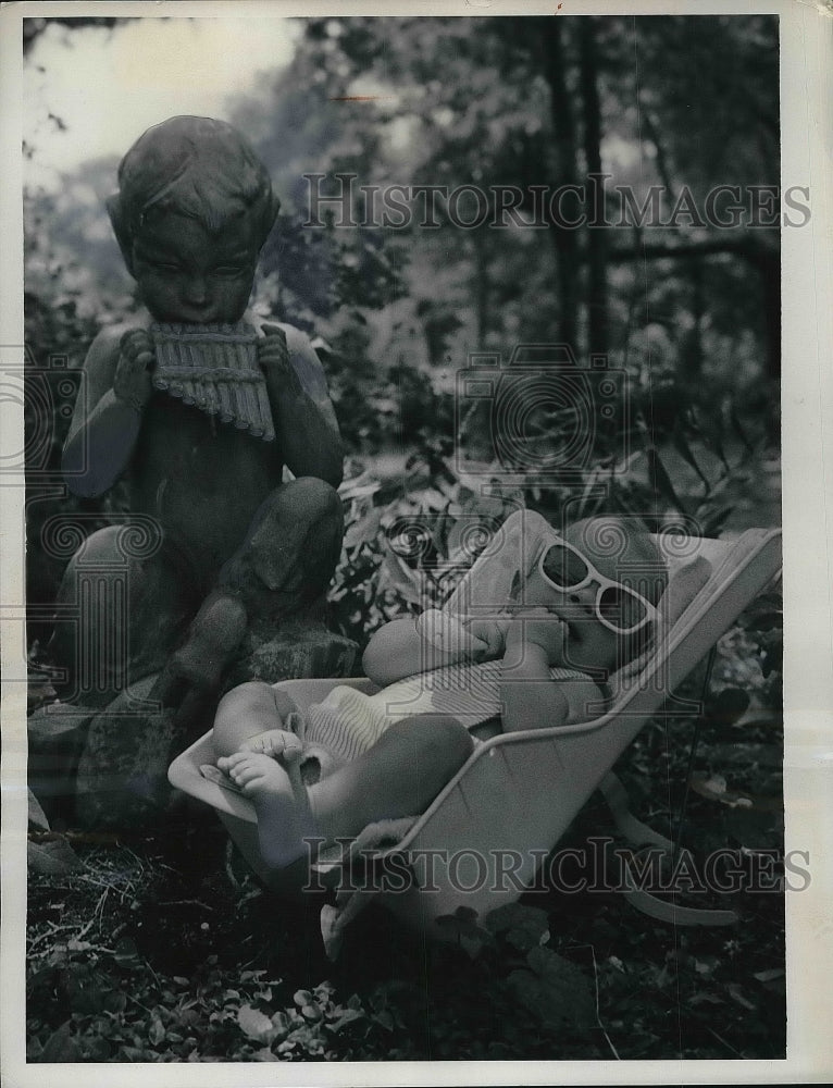 1962 Pan statue &#39;babysits&#39; baby Doug Lunsden in garden, Manteo, NC - Historic Images