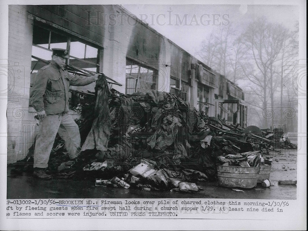 1956 Fireman Examines Charred Clothing From Church Fire  - Historic Images
