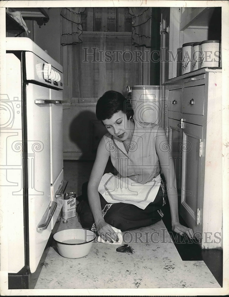 1957 Press Photo Homemaker removes stubborn spots from kitchen floor - nea82165 - Historic Images