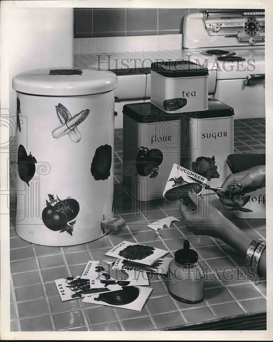 1957 Press Photo A homemaker decorating her kitchen with seed packets - Historic Images