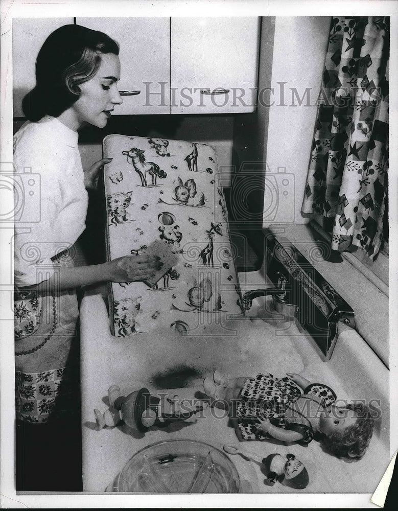 1956 A homemaker scrub baby mattress in a kitchen sink  - Historic Images