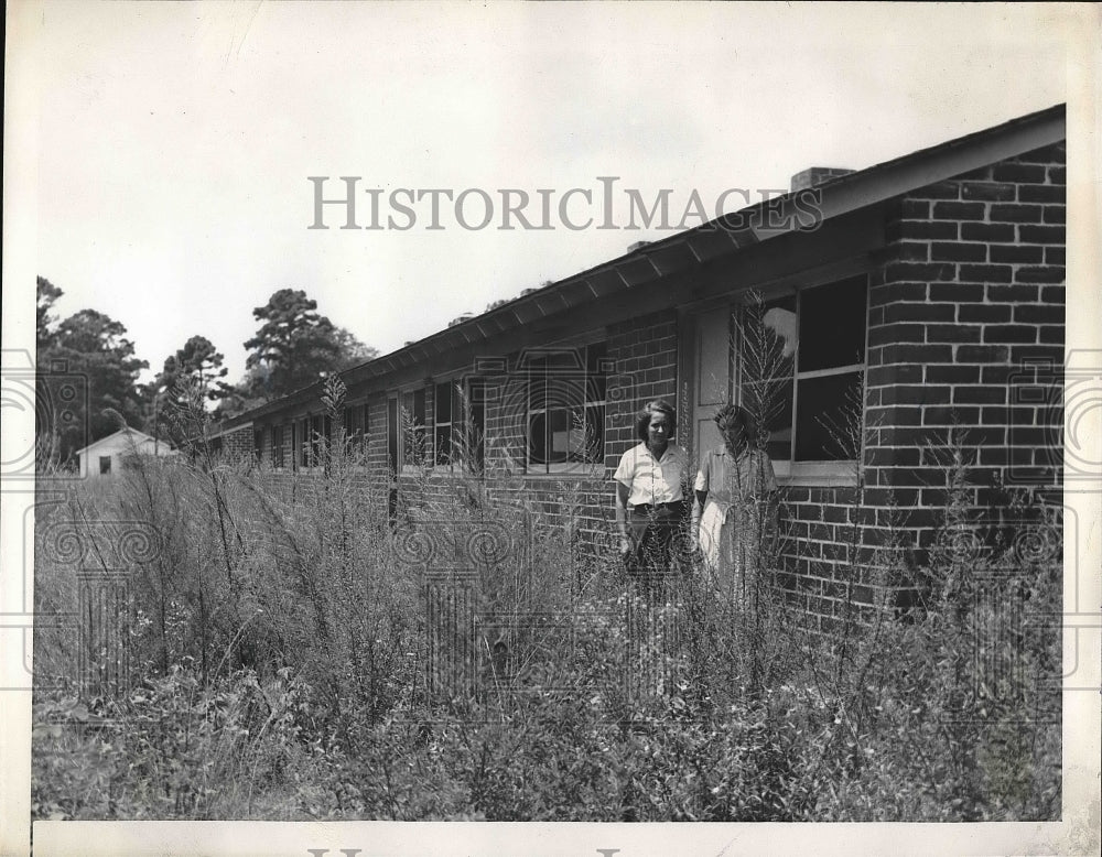 1946 People standing outside of abandoned houses  - Historic Images