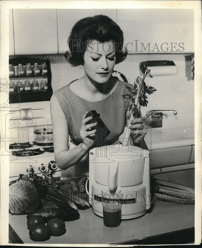 1962 Press Photo A woman using a vegetable juicer - Historic Images