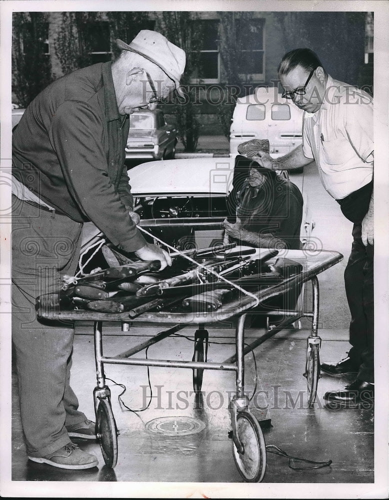 1963 Press Photo Workers unloading guns from car - nea83143 - Historic Images