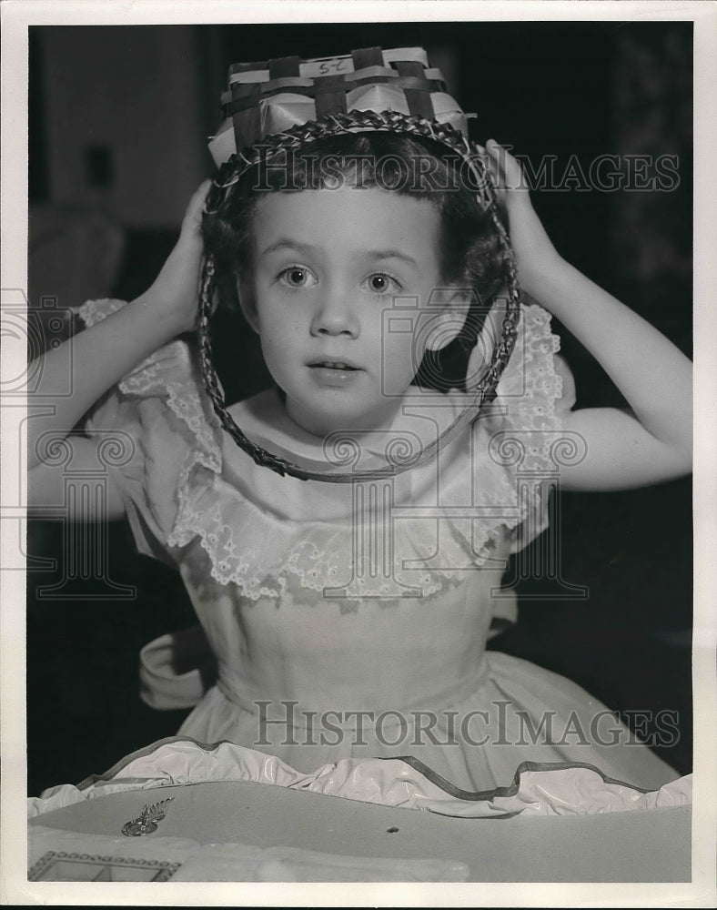 1953 girl using overturned basket as hat  - Historic Images