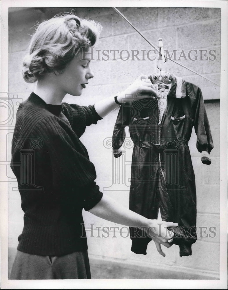 1953 Press Photo woman holding up a washable snowsuit for a small child - Historic Images