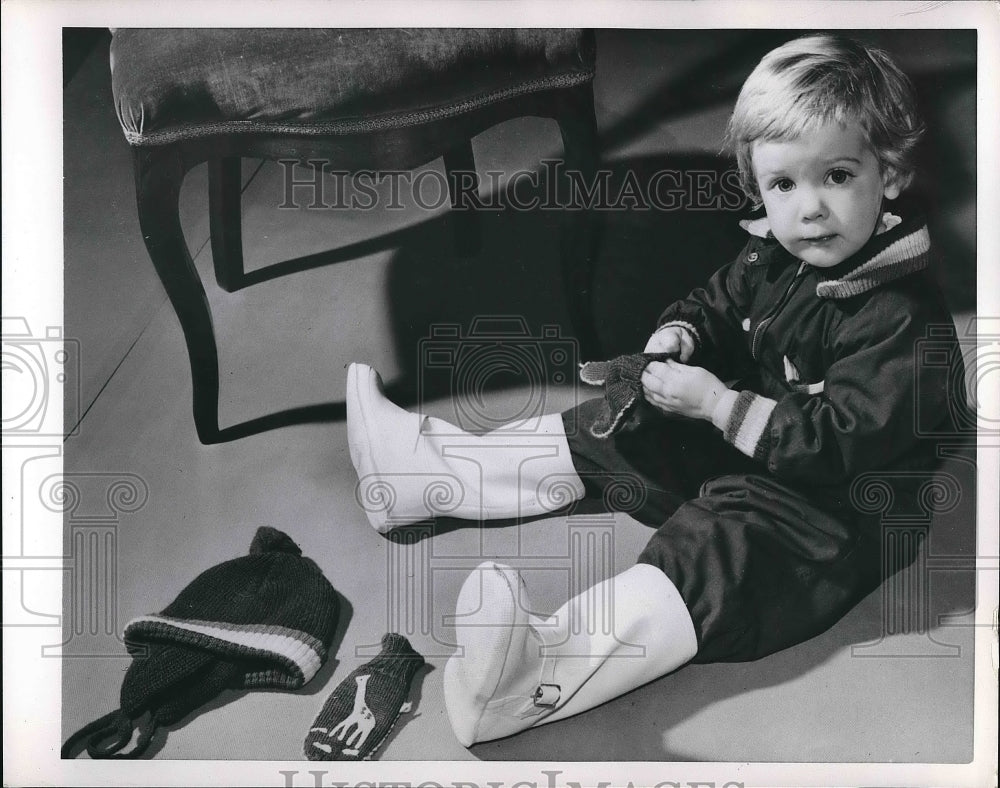 1953 A young child playing with gloves  - Historic Images