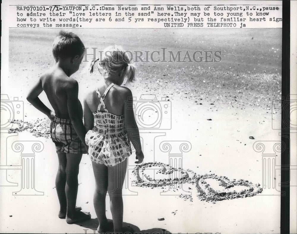 1957 Dana Newton &amp; Ann Wells Admire Their &quot;Love Letter&quot; in The Sand - Historic Images