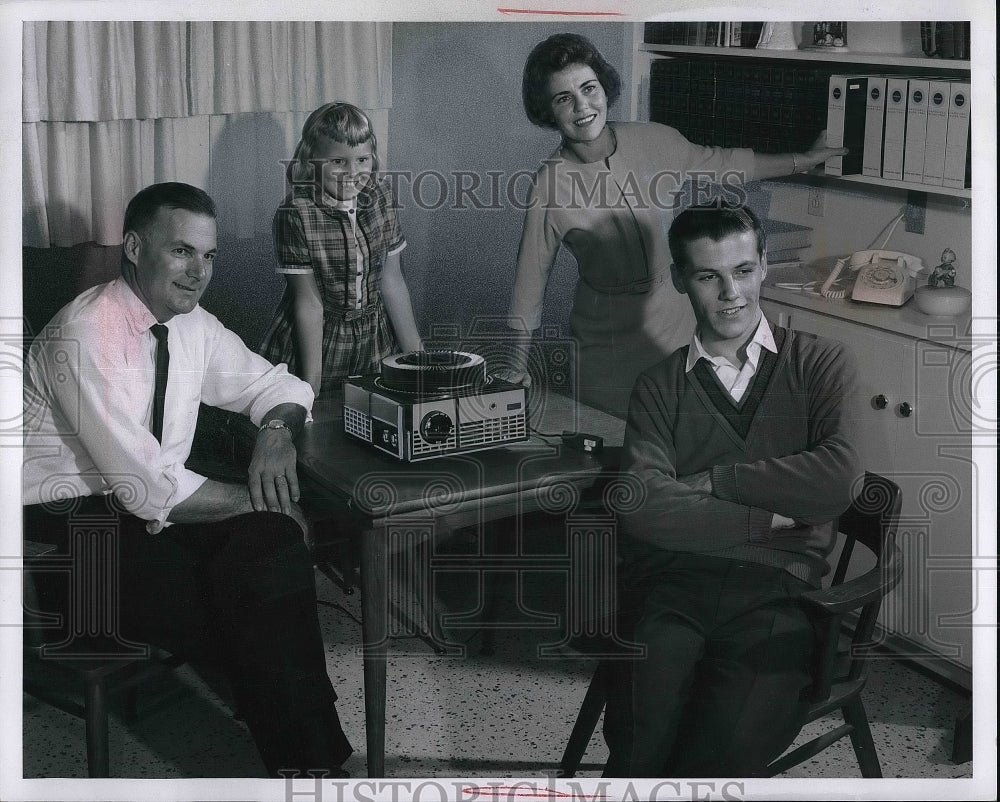 Family looks at slides projected  - Historic Images