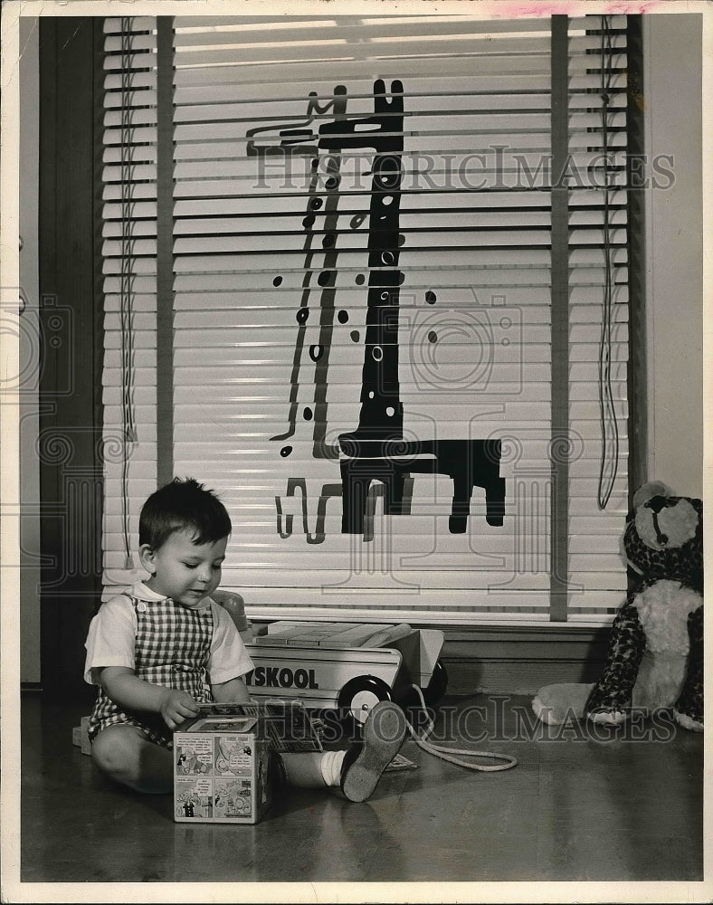 1962 A baby in a brightly decorated nursery  - Historic Images