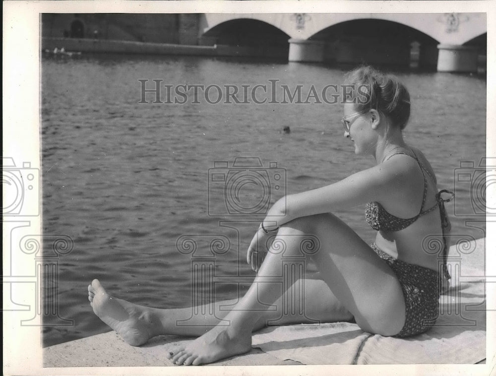 1945 A young French woman sunbathes along the Seine river in Paris - Historic Images