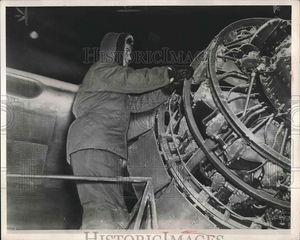 1948 Press Photo A man works on plane engine at Elgin Field in cold weather - Historic Images