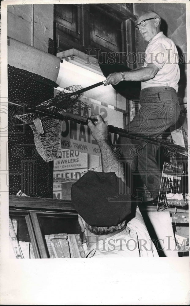 Policeman and Store Owner Setting Trap with Net  - Historic Images