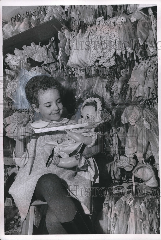 1968 Renee Polish with racks of doll clothes in Enchanted Toy Shop. - Historic Images