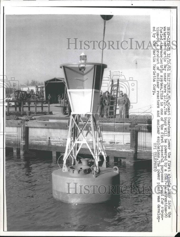 1961 Press Photo Coast Guardsmen lower first atomic buoy into the waters of - Historic Images