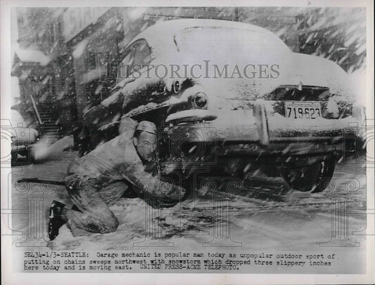 1952 A man puts snow chains on tires in Seattle, Wash.  - Historic Images