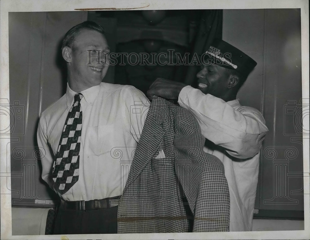 1946 Mr MacKiewicz helped on with his jacket  - Historic Images
