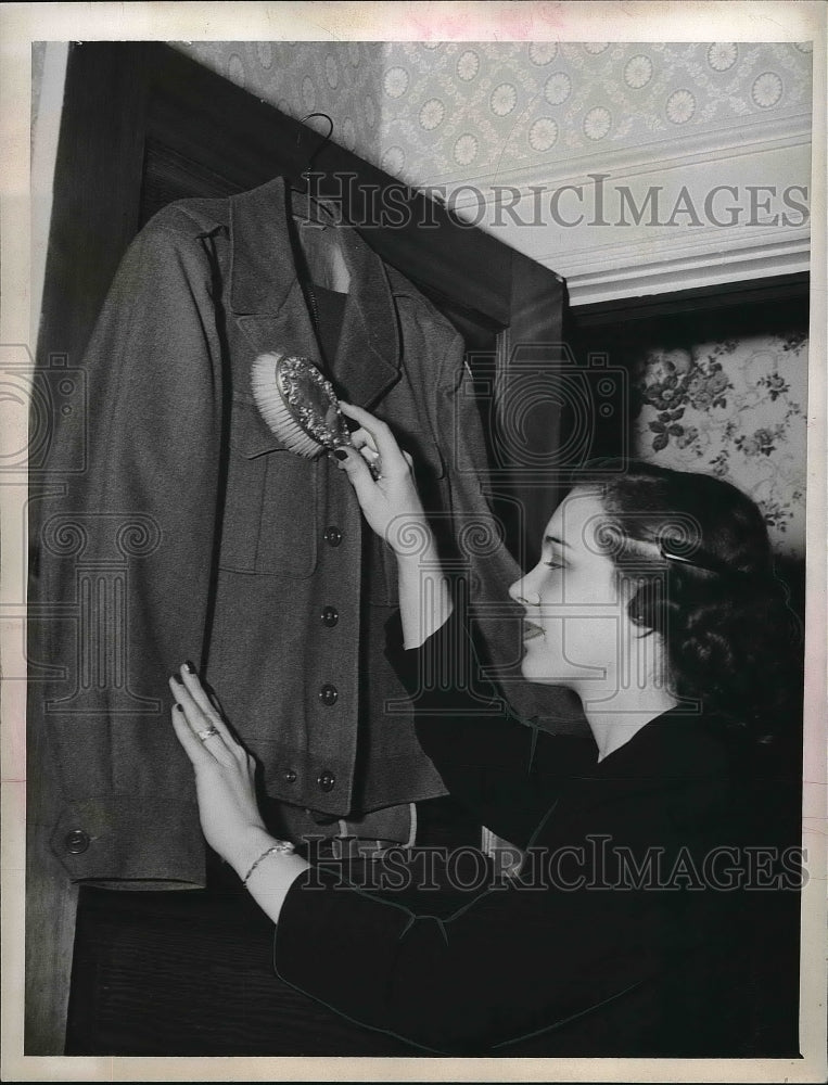 1940 Mrs. Metta Herbert brushing a jacket - nea96323 – Historic Images