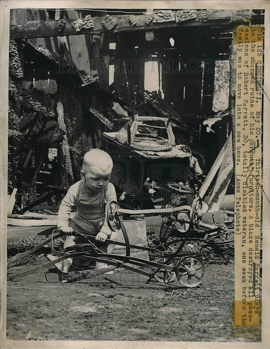1949 tot Ronald Barrett plays in ruins of fire at family home - Historic Images