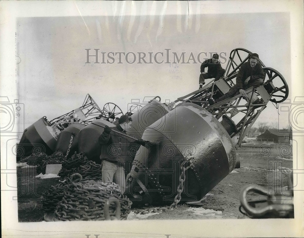 1944 US Coastgurd men cleaning light buoys that will be placed in - Historic Images