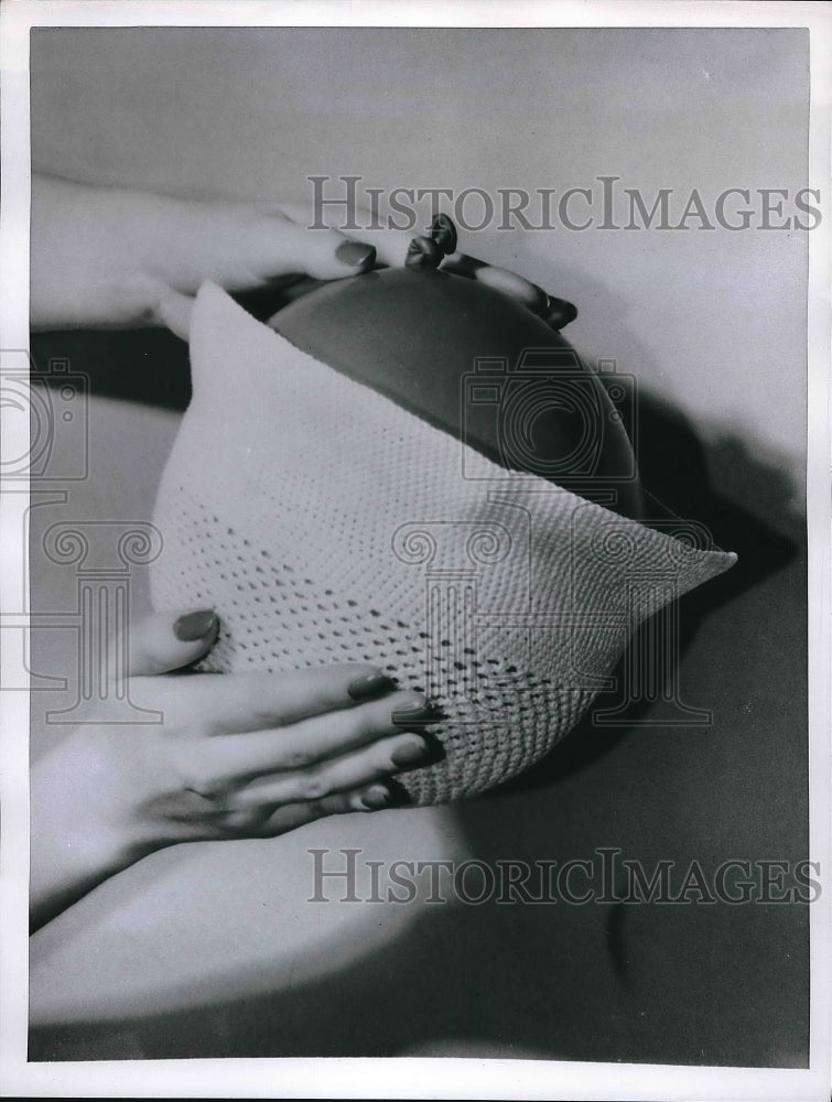 1955 A woman in process of washing a crocheted hat  - Historic Images
