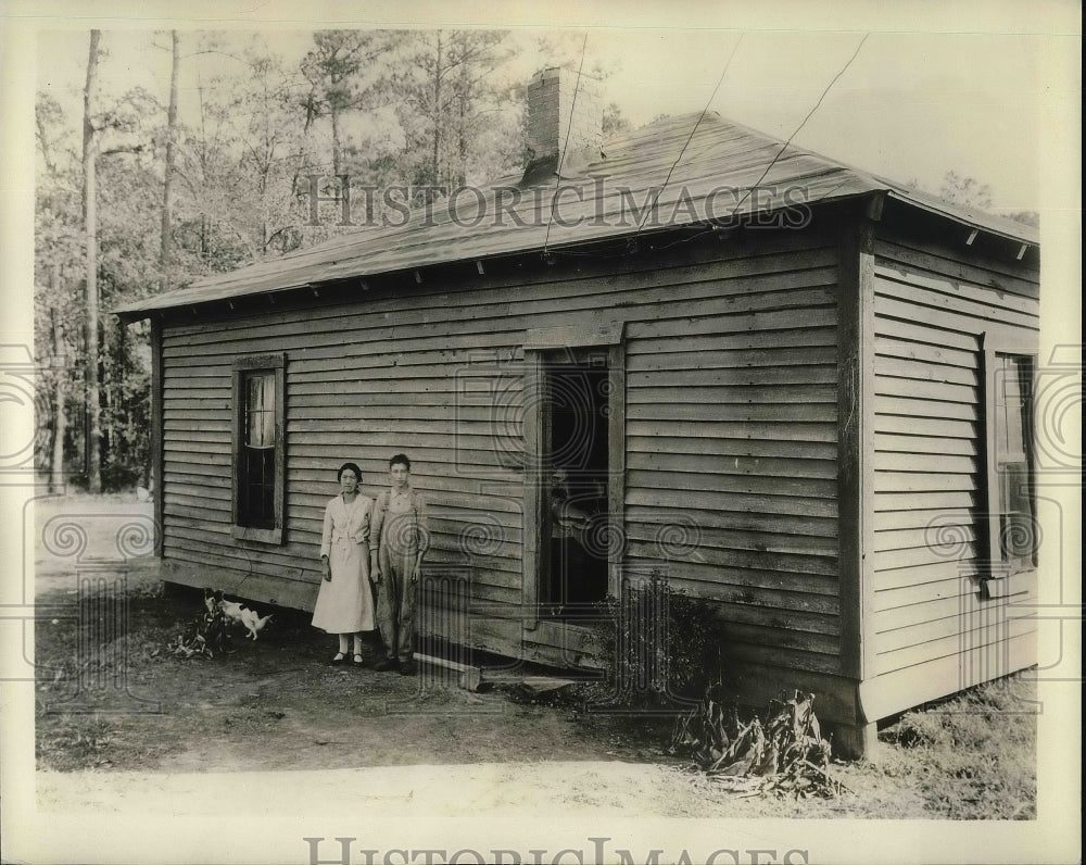 1934 Press Photo couple standing next to one room home in rural hills of Alabama - Historic Images