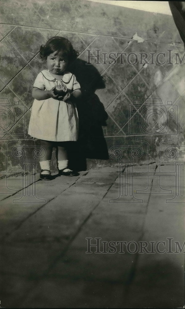 1931 Press Photo Young girl standing against wall - Historic Images