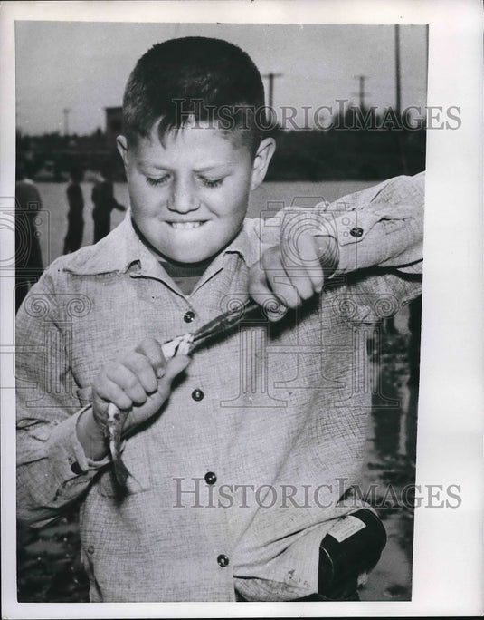 1963 Press Photo Young boy removing hook from fish-Historic Images