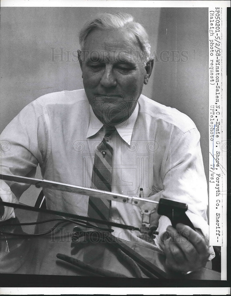 1958 Press Photo Ernie Shore, looking over a hacksaw as a murder weapon. - Historic Images