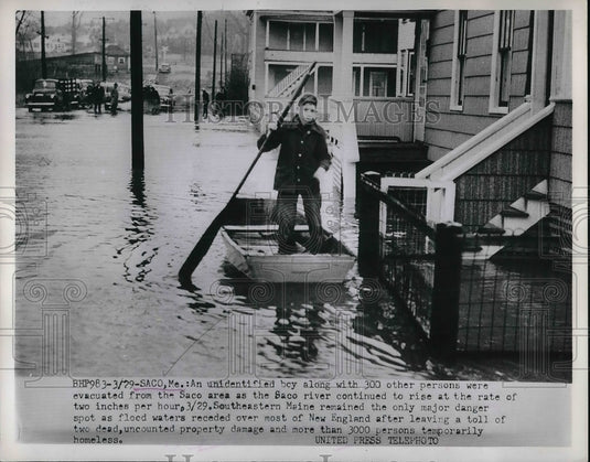 1953 Press Photo young boy making his way through flood waters on a boat - Historic Images