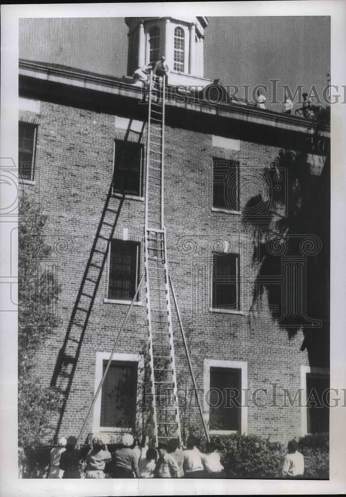 1951 Fireman raised ladder Marine Hospital man on roof - Historic Images