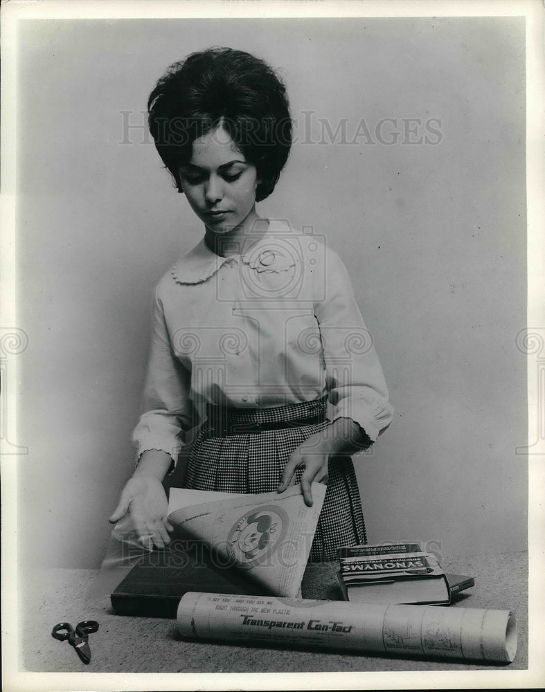 1962 Press Photo Lady Covering Books - Historic Images