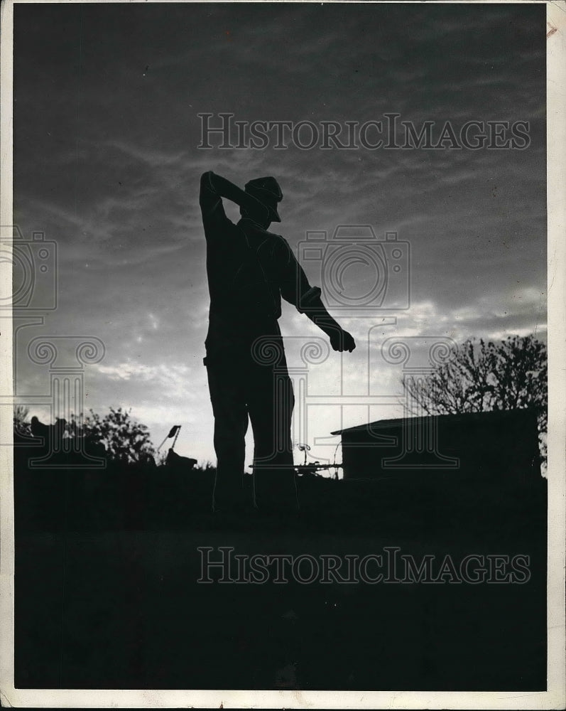 1941 Press Photo Farmer Bunker takes his early-morning stretch as he starts day - Historic Images