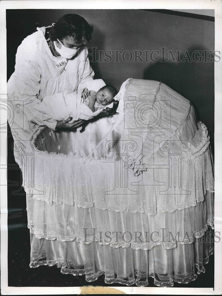 1948 Press Photo Juan Ramon Mercado Placed In New Bassinet By Mrs Robert Draddy - Historic Images