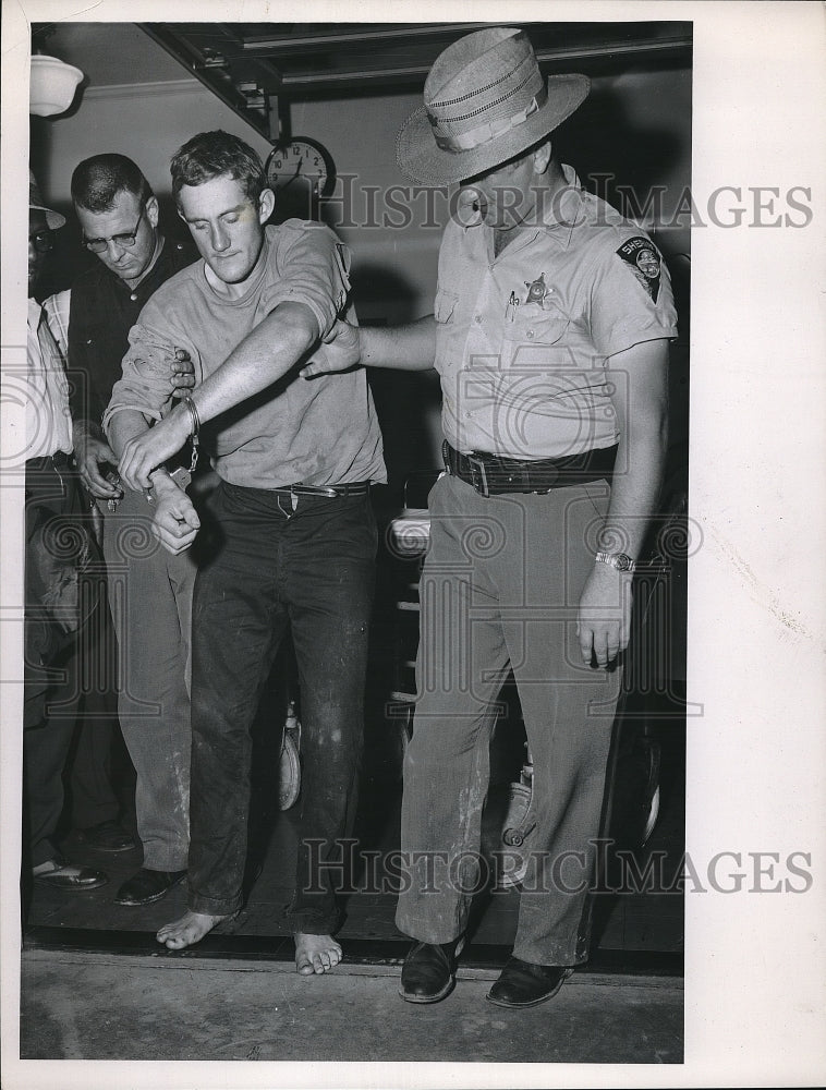 1962 Press Photo Man handcuffs by two policeman. - Historic Images