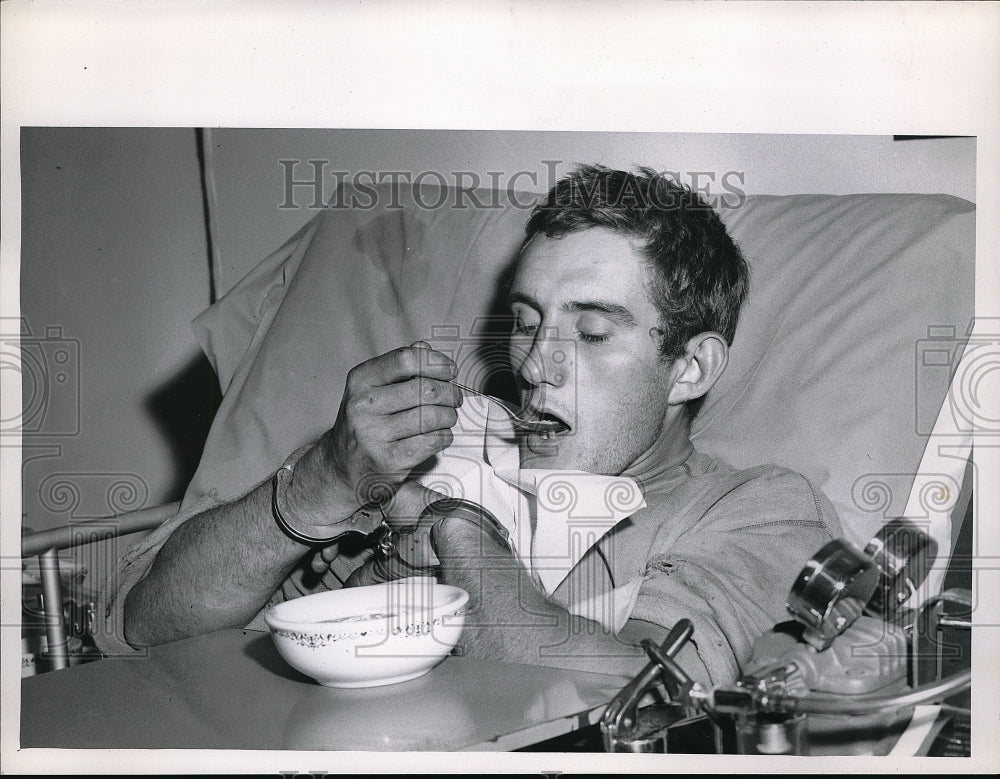 1960 Press Photo Man eat with handcuffs in Hospital Bed. - Historic Images