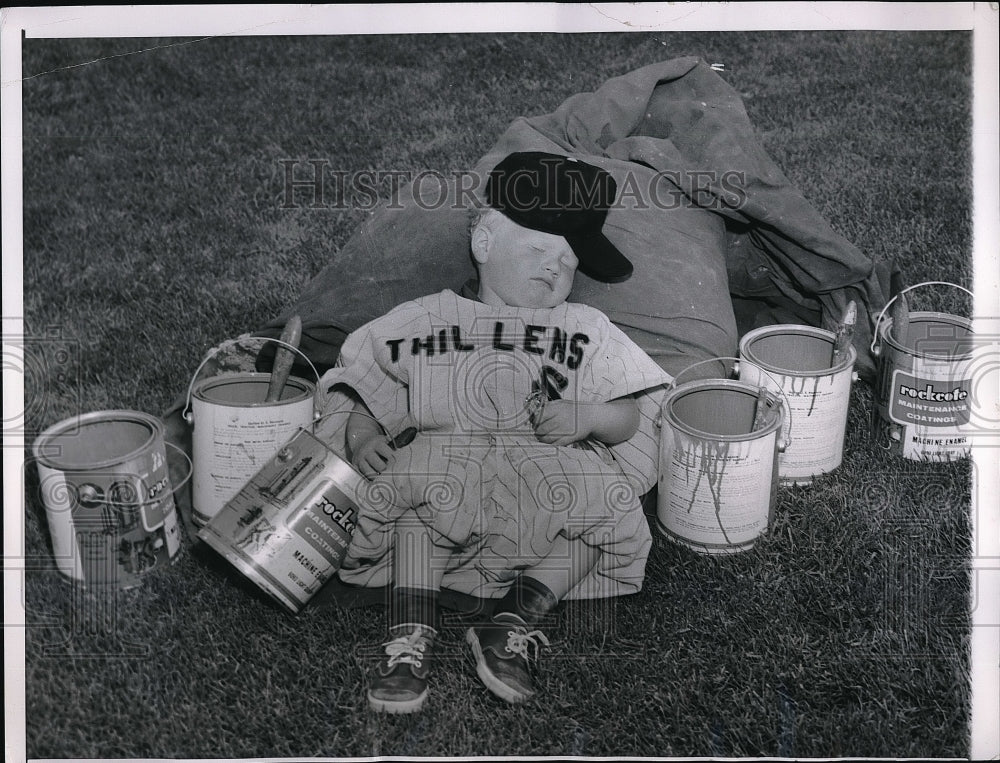 1961 Jamie Jockum asleep among paint buckets - Historic Images