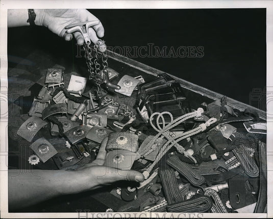 1952 Press Photo Piles belt-buckles, shoulder of pieces & handcuffs w/c were - Historic Images