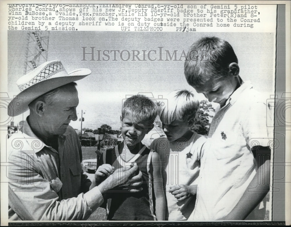 1965 Andrew Conrad, son of Gemini 5 Pilot show his Deputy badge. - Historic Images