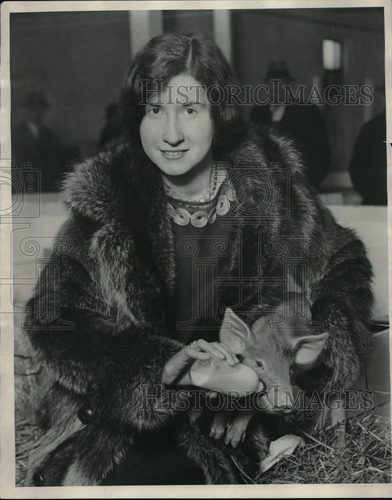 1928 Miss Anne Howe fees Squaler a week old piglet. - Historic Images