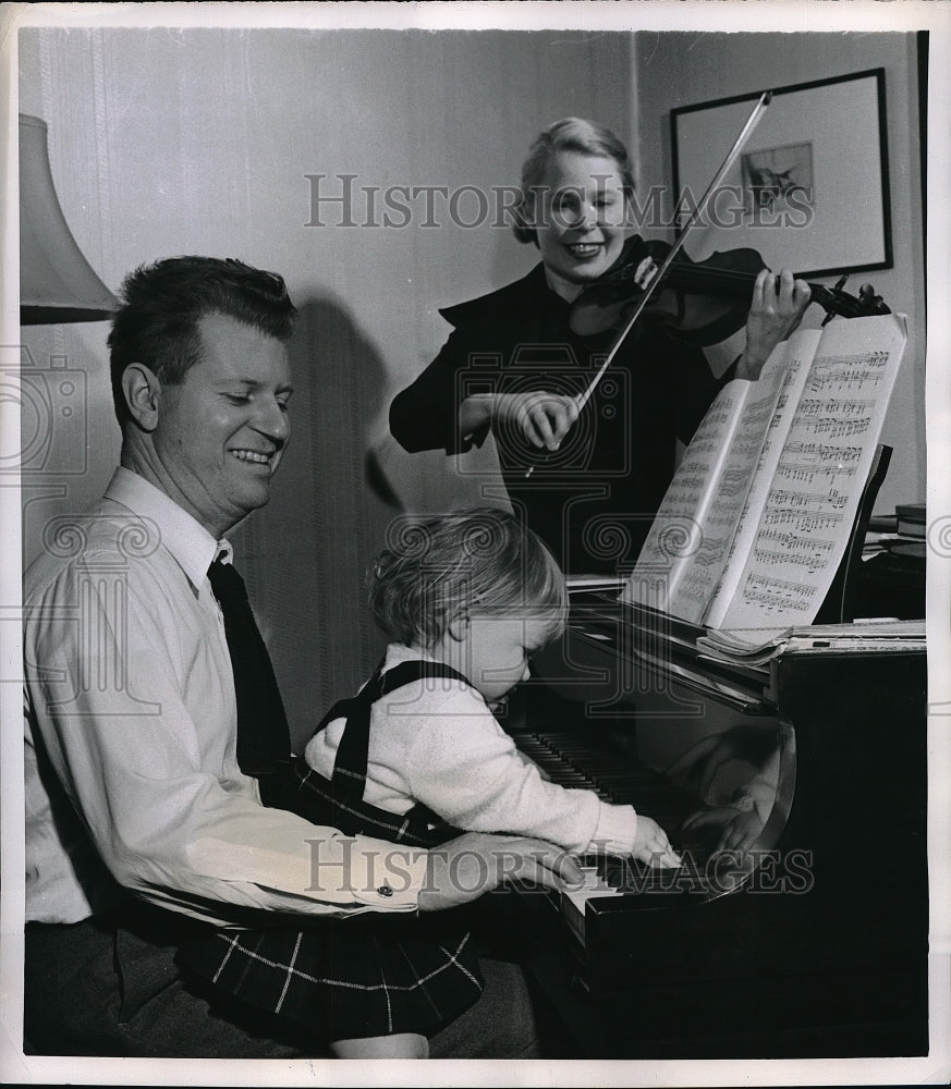 1952 Allison helps her dad play the piano while mom plays violin - Historic Images