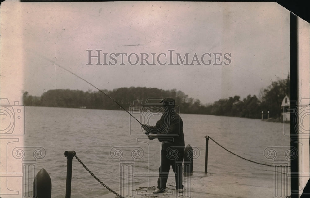 1919 man standing lakeside on dock fishign - Historic Images