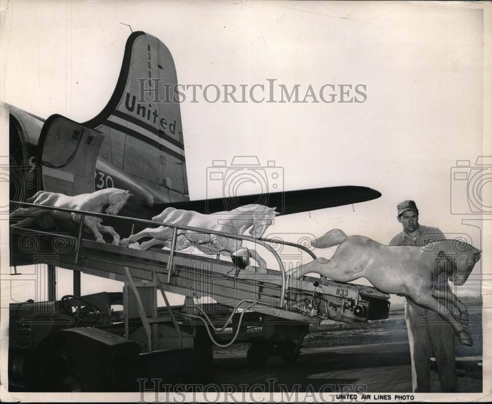 1951 Richard Sawyer, United Air Lines Agent, unloads plastic horses - Historic Images