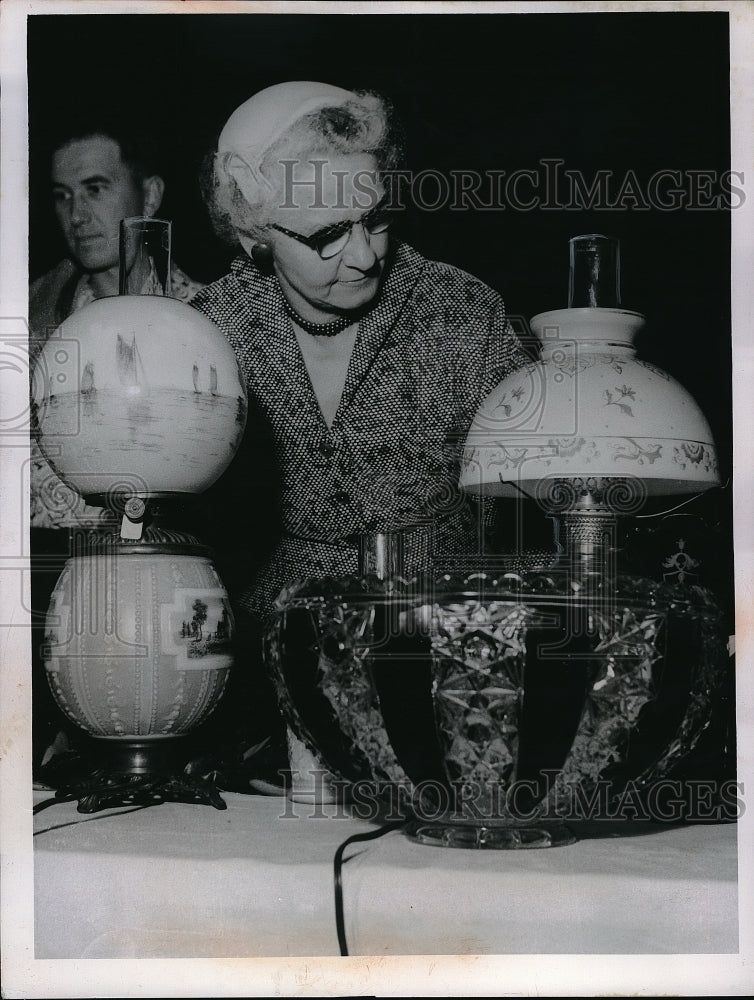 1955 Press Photo A woman examines lamps at antiques auction in Cleveland, Ohio - Historic Images