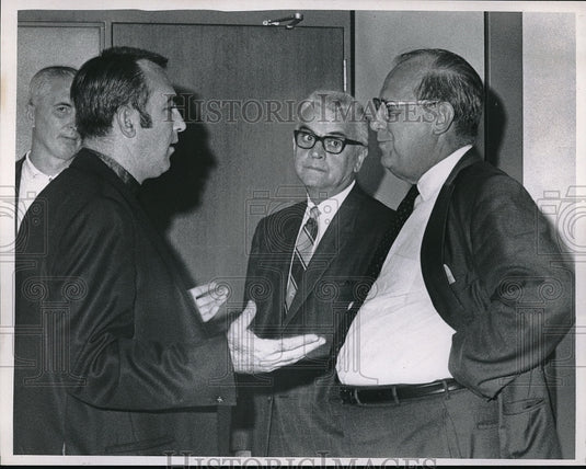 1968 A grouo of men having a discussion - Historic Images
