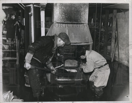 1934 Wm Meacher & Seymour Siegel stoke a furnace at their NY home - Historic Images