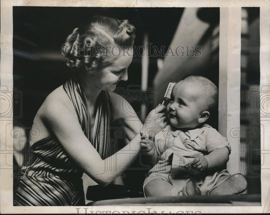 1939 Press Photo Model Brushes a Baby's Hair at Hair & Beauty Fair in London - Historic Images