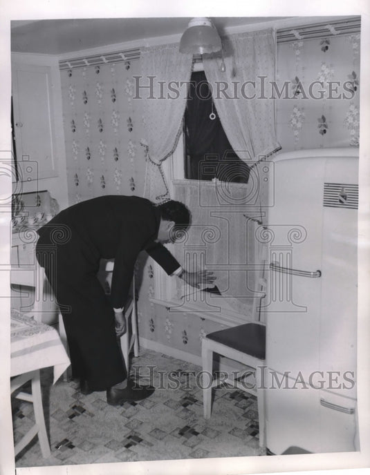 1946 Man pointing to where bullet entered home of Mrs. Olga Rocco - Historic Images