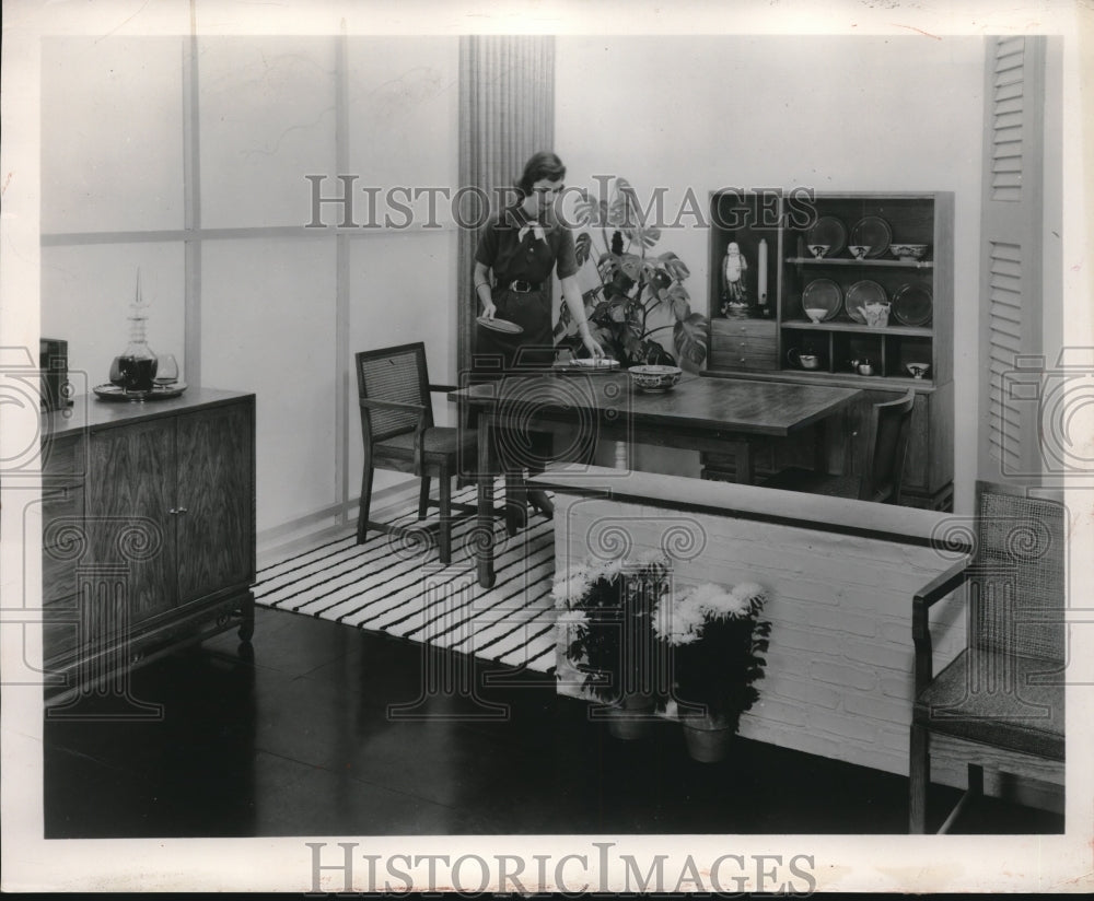 1956 Woman sets dishes on dinette set in a homes kitchen-Historic Images