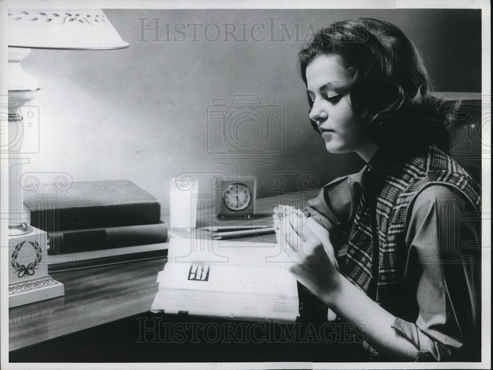 1961 A teen ager studying a book at her desk  - Historic Images